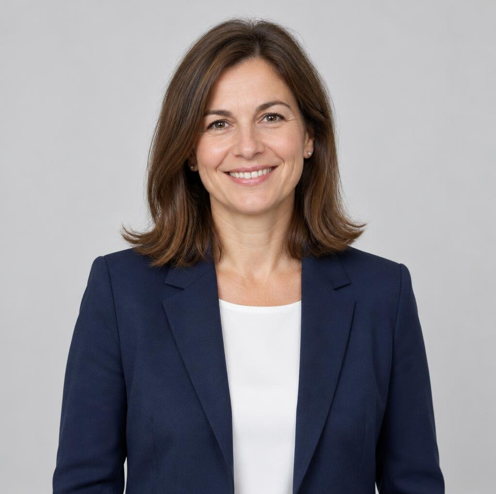 Portrait of a smiling woman in her forties with shoulder-length brown hair in a blazer